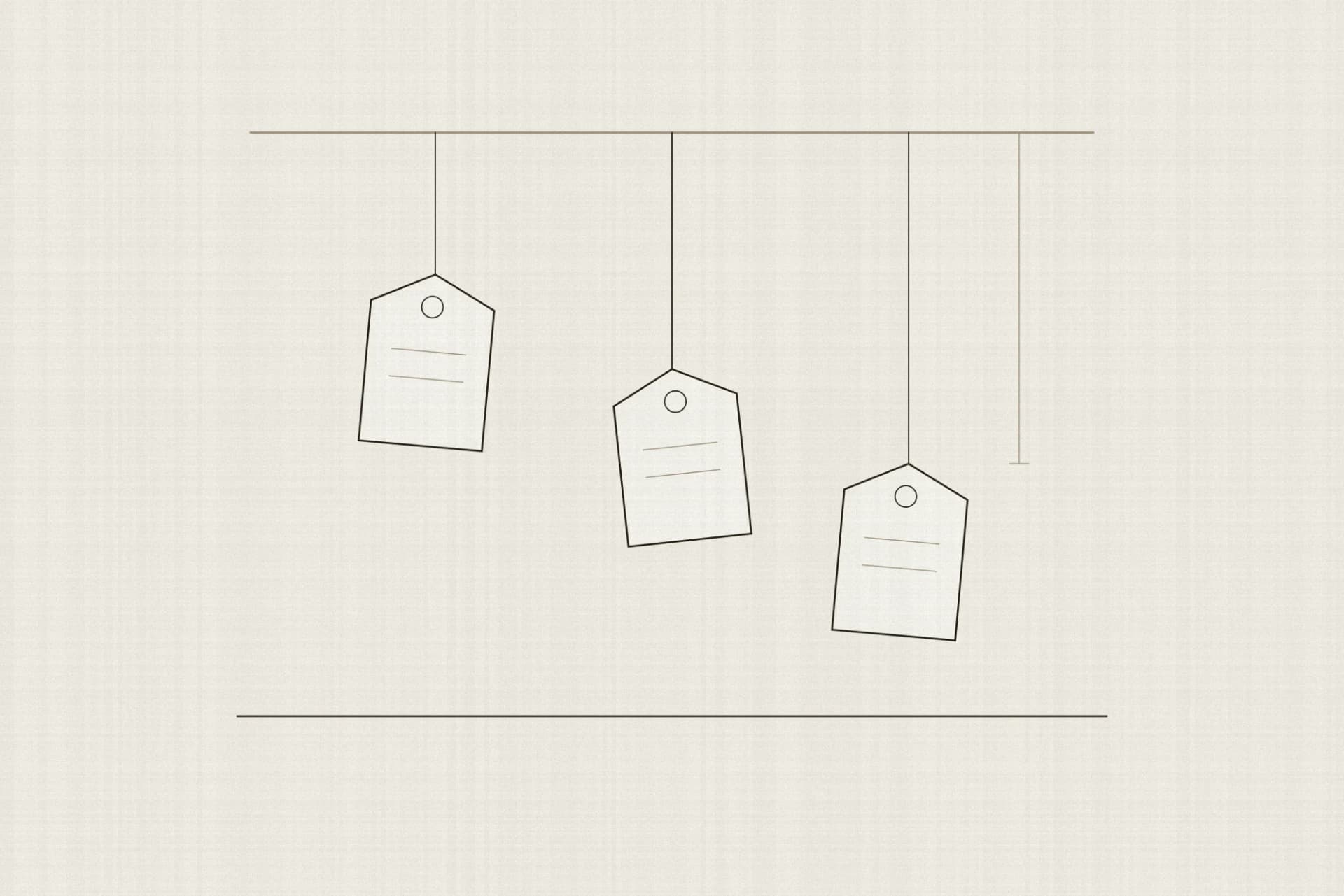 Three blank swing tags hanging from one rail on strings of three different lengths, each above a folded garment on a counter, with a measuring bracket beside the longest string.